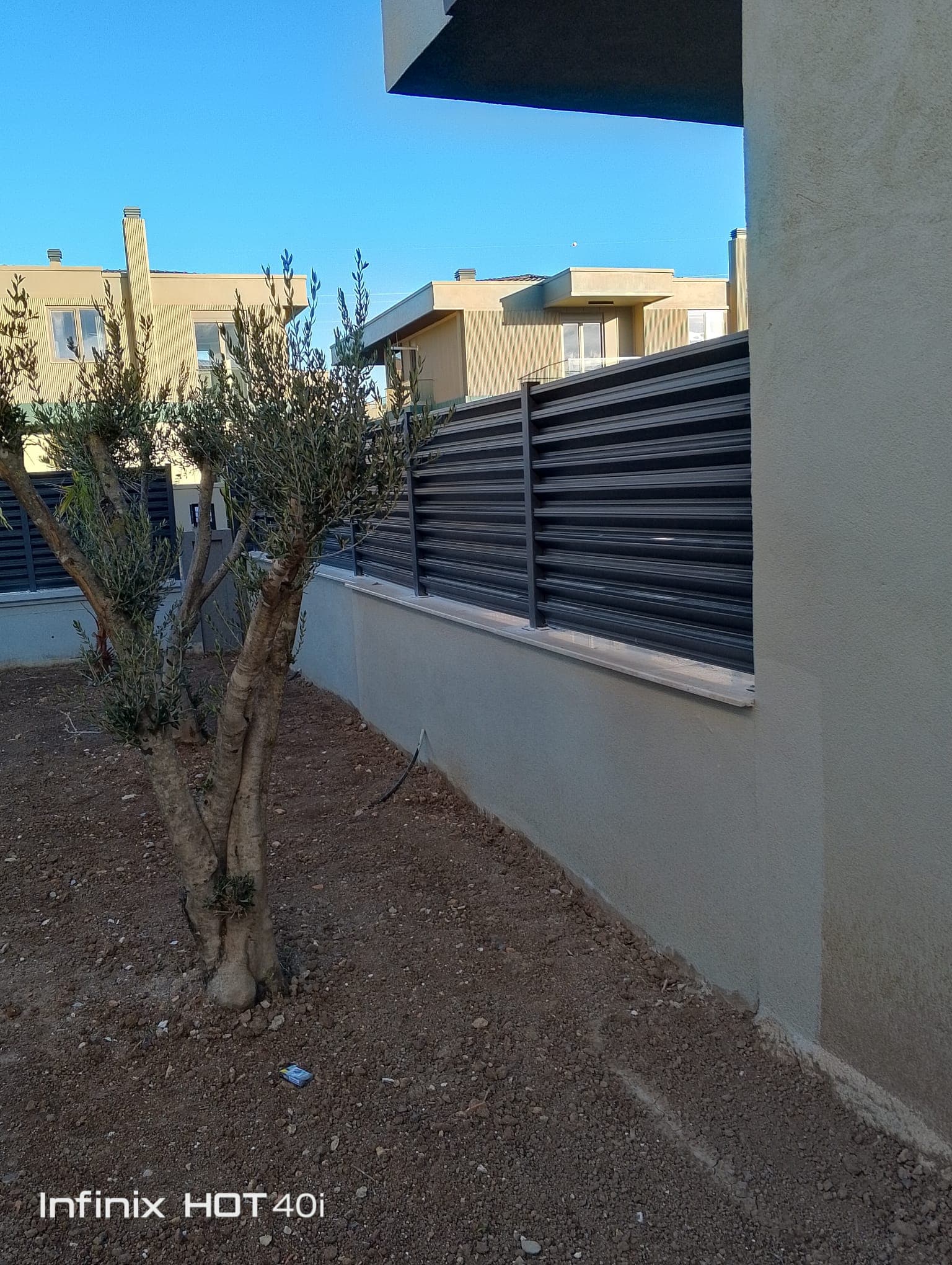 Horizontal aluminium louvre fence around a modern garden