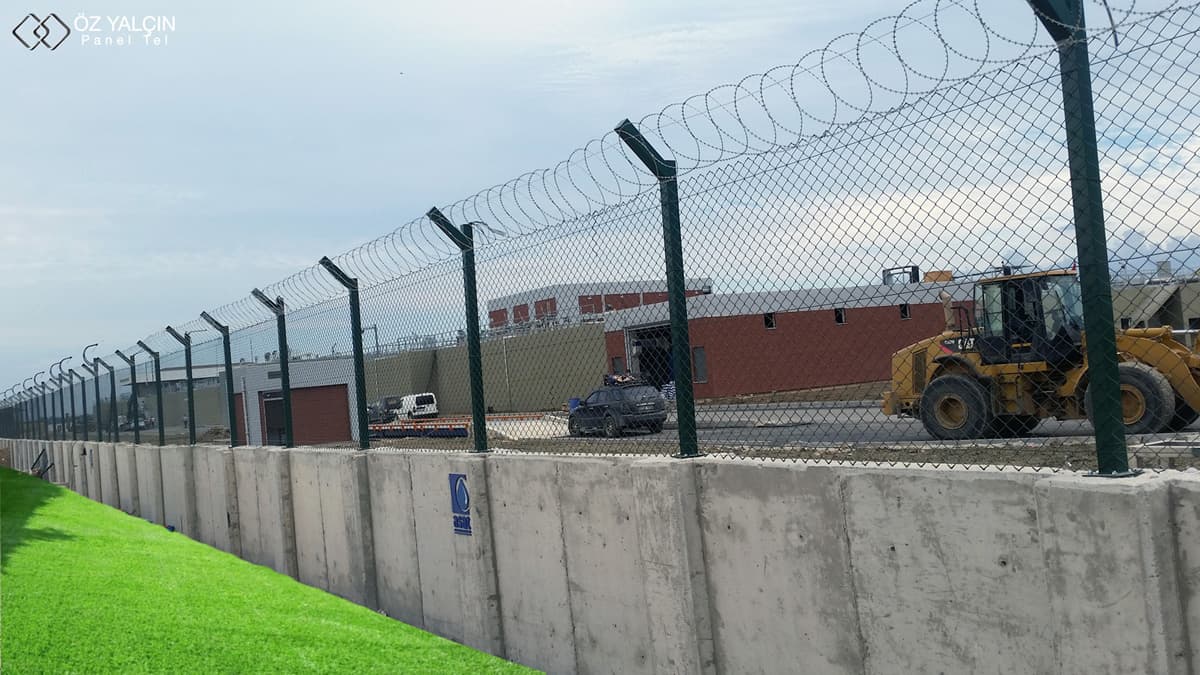 Razor wire barrier mounted on top of a factory perimeter wall
