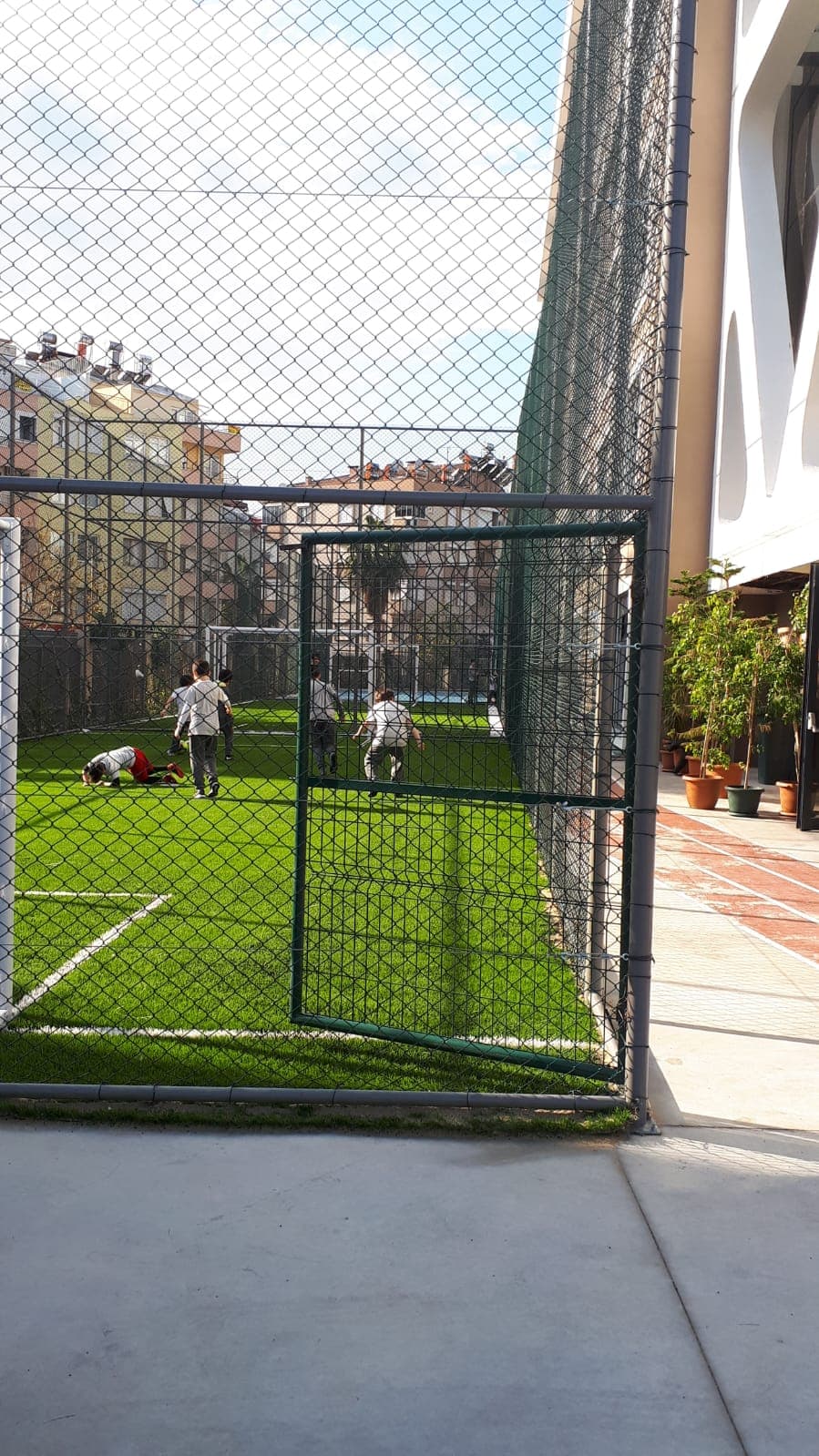 Green mesh cage system enclosing the sports ground in a school yard