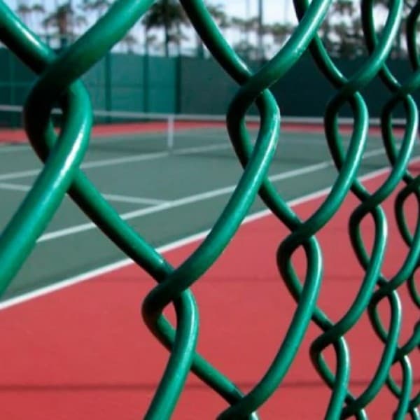 Close view of green PVC coated woven wire mesh enclosing a tennis court